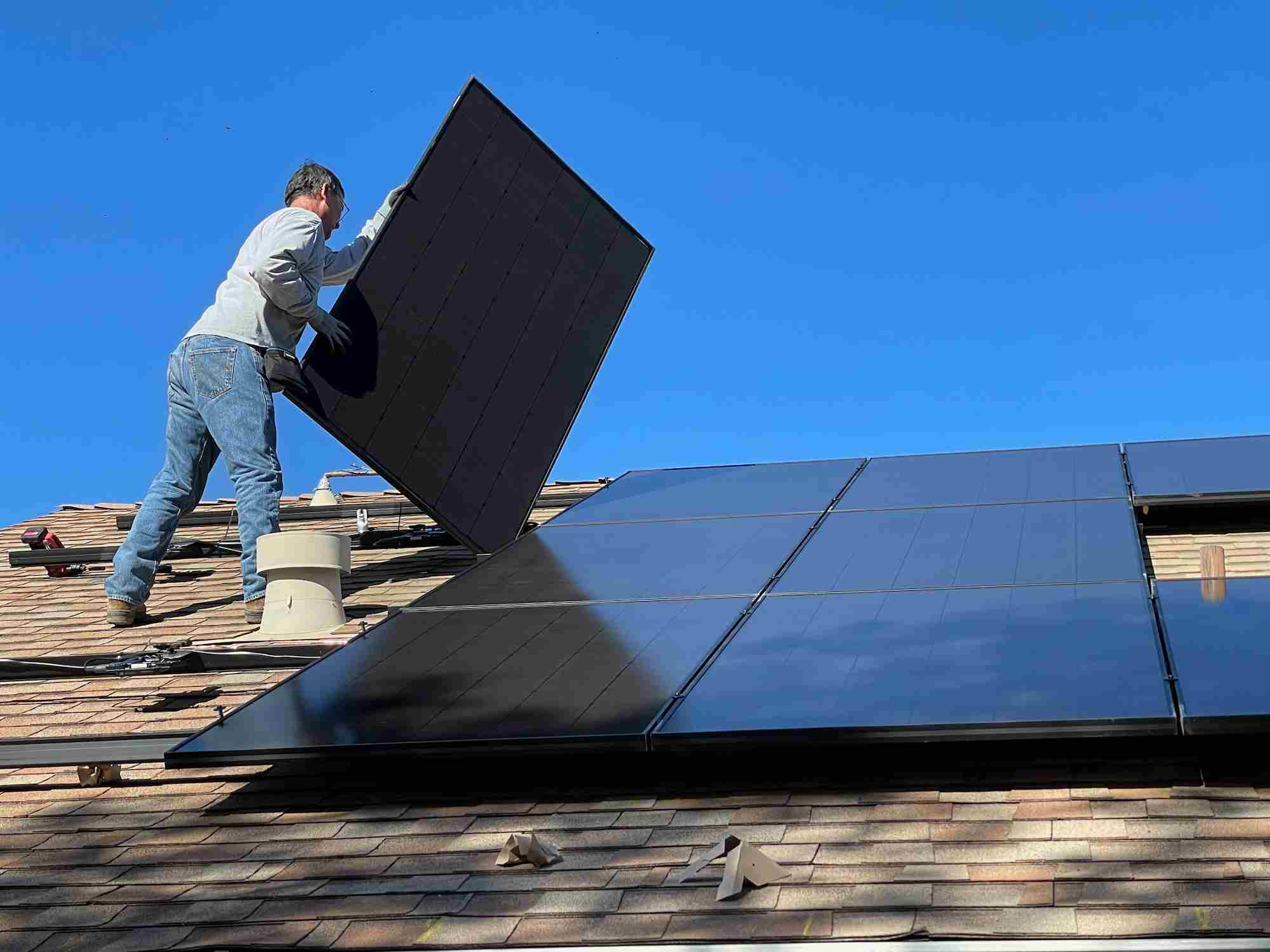 Installateur plaatst zonnepanelen op een dak